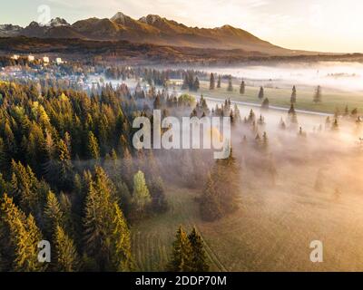 Bella mattina in High Tatra Mountains. Nebbia su caduta Foliage. Vista aerea drone. Foto Stock