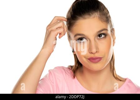 Ritratto di giovane donna pensiva graffiando la testa su bianco sfondo Foto Stock