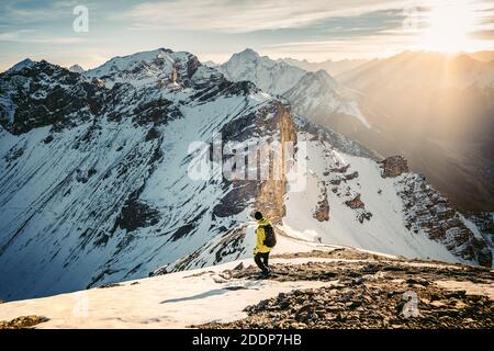 Attivo scalatore zaino uomo con giacca gialla e zaino arrampicata in montagna Alpi durante l'alta altitudine acclimatazione a piedi. Estremamente attivo Foto Stock