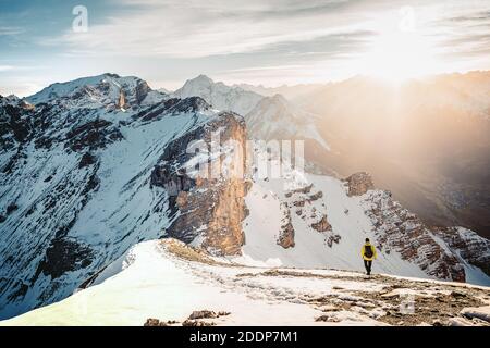 Attivo scalatore zaino uomo con giacca gialla e zaino arrampicata in montagna Alpi durante l'alta altitudine acclimatazione a piedi. Estremamente attivo Foto Stock