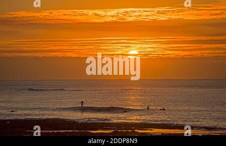 Swansea, Regno Unito. 26 Nov 2020. Surfers che fa il massimo del tempo stupefacente mentre il sole sorge sopra la Baia di Langland vicino a Swansea in una mattina fredda e gelida dell'autunno. Credit: Phil Rees/Alamy Live News Foto Stock
