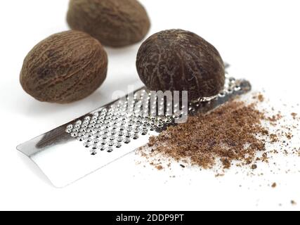 Noce moscata, Myristica fragrans, frutta e Grattugia contro uno sfondo bianco Foto Stock