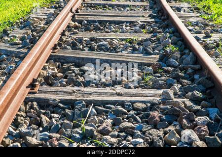 Vecchie ringhiere arrugginite con doghe di legno su pavimento roccioso Foto Stock