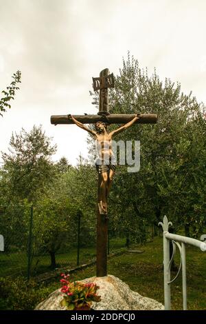 Piona, Colico, Provincia di Lecco, Regione Lombardia, sponda orientale del Lago di Como, Italia.. Abbazia cistercense di Piona o Priorato di Piona. Crocifisso nel giardino d'ulivo dell'abbazia. Foto Stock