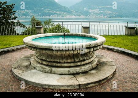 Piona, Colico, Provincia di Lecco, Regione Lombardia, sponda orientale del Lago di Como, Italia.. Abbazia cistercense di Piona o Priorato di Piona. La fontana nel giardino che si affaccia sul Lago di Como. Foto Stock