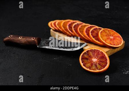 Vista dall'alto delle sezioni di sangue arancione su sfondo nero Foto Stock