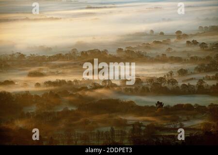 RITRASMESSO con una qualità migliorata. Il sole sorge su un Worcestershire fogy visto dalle colline di Malvern. Foto Stock