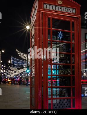 L'albero di natale di St. James si riflette sulla scatola telefonica rossa in Lower Regents Street, Londra. Foto Stock