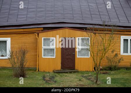 Villaggio lituano. Antica casa tradizionale in legno giallo Foto Stock