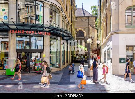 La gente va a fare shopping nella principale via dello shopping di Ginevra, passando per il negozio Franz Carl Weber, una famosa catena di negozi di giocattoli svizzeri. Foto Stock