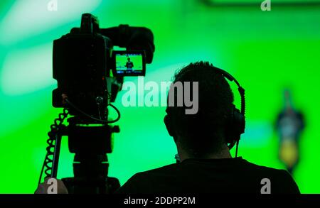 Vista posteriore di un videografo accanto a una registrazione fotocamera Foto Stock