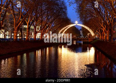 Königsallee con arco di Natale tradizionale e riflesso della luce in acqua. Foto Stock