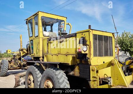 Livellatrice stradale - attrezzatura per la costruzione di strade pesanti. Motorgrader industriale a terra Foto Stock