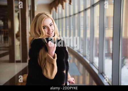 Bella ragazza guarda attraverso la finestra del centro business Foto Stock