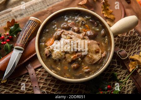 Uno stufato di cervo, accanto ad un coltello fatto in casa, fatto di un cervo selvatico, con castagne incluse negli ingredienti. Inghilterra GB Foto Stock