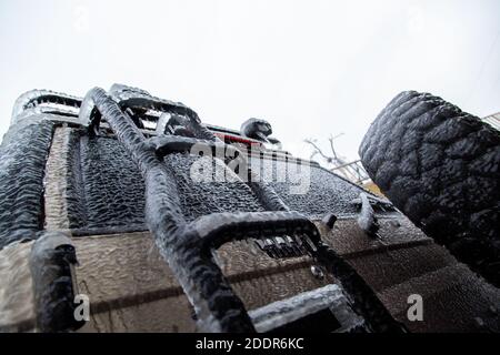 Scalinata molto ghiacciata, ruota di scorta sul SUV posteriore in inverno, quinta porta. Giù verso l'alto. Foto Stock