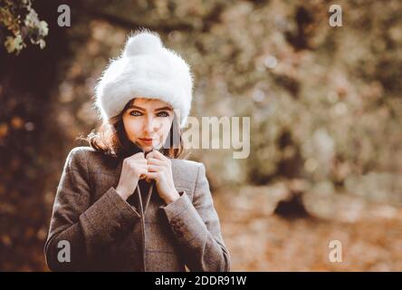 Ritratto di bella giovane donna che indossa una giacca in tweed e un cappello nella campagna inglese. Foto Stock