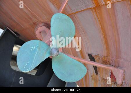 Propeller a bordo in una marina secca.Propeller in ricostruzione. Sotto la nave. Nave grande in riparazione su bacino asciutto Foto Stock