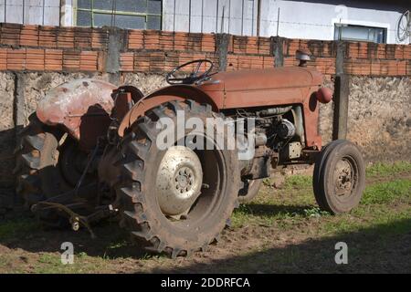 Il vecchio trattore utilizzato in agricoltura si fermò di fronte alla casa sulla parte superiore del marciapiede, in una piccola città all'interno di San Paolo, in Brasile Foto Stock