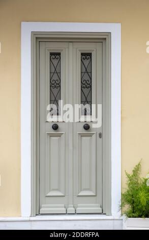 Porta d'ingresso in legno, sfondo della parete di colore giallo beige, edificio residenziale nella città vecchia di Plaka, Atene Grecia Foto Stock