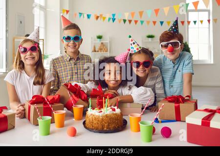 Ritratto di una ragazza di compleanno afro americana con i suoi amici che sono al tavolo con i regali. Foto Stock