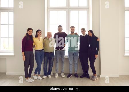 Ritratto di gruppo presso la finestra di felici e positive diverse persone di diversi generi, razze ed età. Foto Stock