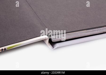 Apri un fotolibro in una copertina rigida colorata su sfondo bianco dello studio. Primo piano, spazio di copia Foto Stock