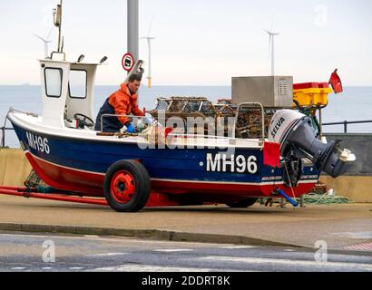 Due pescatori nella loro barca MH96 Shores distanti su Redcar Esplanade caricamento granchio pentole preparazione per andare a mare a. impostarli Foto Stock