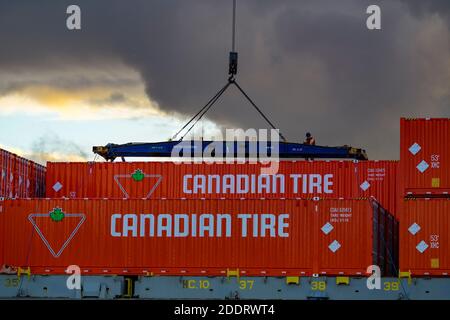 Stevedore sta scaricando casse di contenitori di pneumatici canadesi, terminal Lynnterm, porto di Vancouver, North Vancouver, British Columbia, Canada Foto Stock