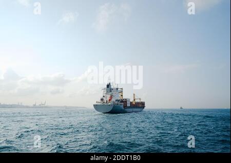 Nave container completamente carica che si muove attraverso Bosforo. Barca pesante di carico che naviga verso il mare. Foto Stock