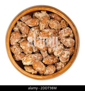 Mandorle candite in una ciotola di legno. Fatte in casa, in modo speciale, mandorle cotte, noci intere ricoperte di zucchero croccante. Venduto ai mercatini di Natale. Foto Stock