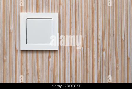 Interruttore luce elettrica bianca sullo sfondo dei pannelli a parete in plastica. Elettricità domestica. Foto Stock