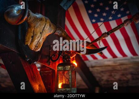 Cranio di bufalo agitato, lampade retrò e arco sulla bandiera americana offuscata sullo sfondo. Concetto di Halloween, sfondo o struttura in stile occidentale Foto Stock