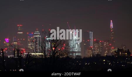 Londra, Regno Unito. 26 novembre 2020. 575 luci a LED a tema blu e bianco si accendono, illuminando i 20 piani principali dello Shard per mostrare gratitudine all'NHS e ai lavoratori chiave durante la pandemia del Covid-19, creando il più alto spettacolo di luci dell'Europa occidentale che si staglia a 1016 metri e visibile sullo skyline da gran parte di Londra. Shard Lights 2020 continua con una mostra natalizia dal 11 dicembre. Basse case suburbane in primo piano in contrasto con lo sfondo. Credit: Malcolm Park/Alamy Live News. Foto Stock