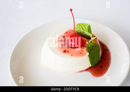 Dessert alla panna cotta condito con ciliegia in un ristorante a Baguio City, Filippine Foto Stock