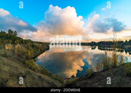 Grandi nuvole al tramonto sul lago in autunno Foto Stock