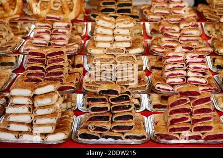 Strudel fatti in casa con vari sapori in vendita al mercato di natale all'aperto. Torte fresche fatte in casa farcite con vari ripieni. Serve natu nazionale Foto Stock