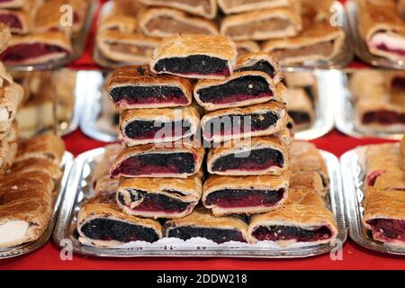 Strudel fatti in casa con vari sapori in vendita al mercato di natale all'aperto. Torte fresche fatte in casa farcite con vari ripieni. Serve natu nazionale Foto Stock