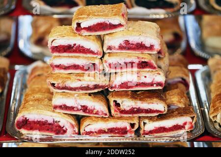 Strudel fatti in casa con vari sapori in vendita al mercato di natale all'aperto. Torte fresche fatte in casa farcite con vari ripieni. Serve natu nazionale Foto Stock