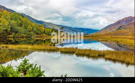 Glen Strathfarrar in autunno con colorati paesaggi autunnali e riflessi nel lago. Highlands della Scozia. Orizzontale, spazio per la copia. Foto Stock