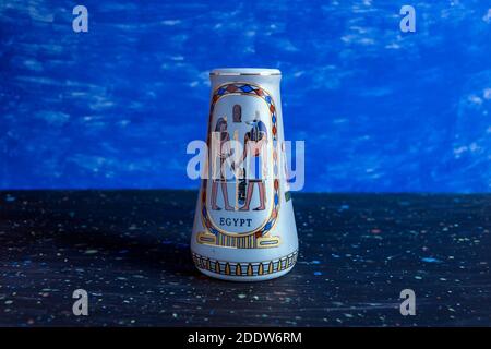 :vaso in porcellana con antico stile egiziano su sfondo blu. Foto Stock