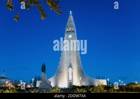 The famous church and tourist attraction Hallgrímskirkja located in downtown Reykjavík, taken at dusk with a clear blue evening sky and lights. Stock Photo