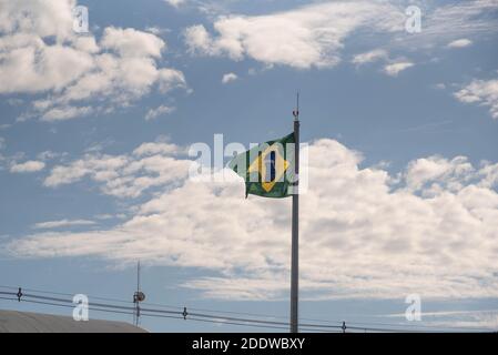 Bandiera del Brasile. Cielo blu e nuvole. Simbolo della repubblica. Giorno dell'indipendenza. Padiglione. Repubblica Federativa del Brasile. Bandiera che vola. Foto Stock