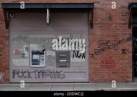 Portland, Stati Uniti. 26 Nov 2020. Messaggi anti-gentriificazione sono raffigurati su Umpqua Bank, in Southeast Hawthorne Street a Portland, Ore., il 26 novembre 2020, dopo un appello alla vigilia del Ringraziamento che ha spinto i manifestanti indigeni ad attaccare simboli di colonialismo, capitalismo e gentriificazione. (Foto di Alex Milan Tracy/Sipa USA) Credit: Sipa USA/Alamy Live News Foto Stock