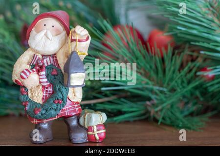 Natale Babbo natale gnome tenendo lanterna e corona con regali, sempreverdi garland, Holiday background Foto Stock