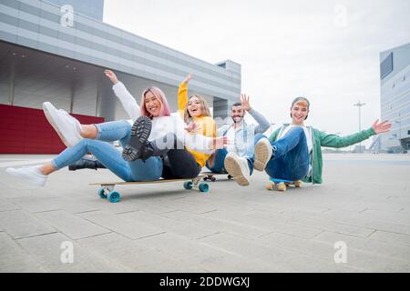 Gruppo di adolescenti che si fooling circa a skate Park - felici giovani amici seduti sullo skateboard - Gruppo di amici allegri divertirsi, concetti su teen Foto Stock