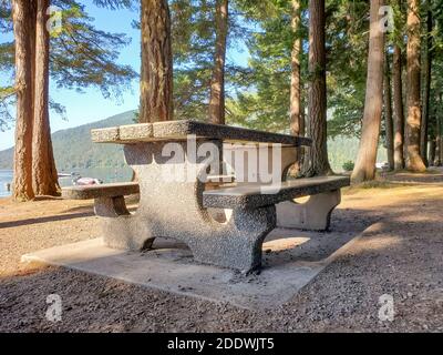 Un tavolo in pietra e panche in pietra nella foresta vicino al Lago Culti a.C. Messa a fuoco selettiva, foto di viaggio, nessuno. Foto Stock