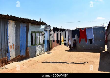 Abbigliamento e biancheria asciugando sulla linea di lavaggio e le case in acciaio ondulato in una borgata a Orlando Ovest, Soweto, Johannesburg, Sud Africa. Foto Stock