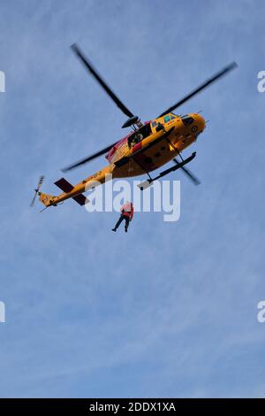 Northumberland County Forest, Ontario, Canada - 19 novembre 2020: Un elicottero Griffon delle forze armate canadesi pratica il sollevamento di un Search and Rescue te Foto Stock