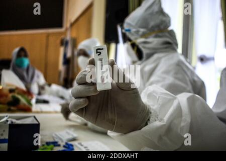 Medan, Indonesia. 26 Nov 2020. Un funzionario sanitario che detiene una striscia di prova che mostra i risultati durante i test rapidi. Il numero di casi di covid-19 in Indonesia è salito a 4,917 in un giorno a 516,753, con il numero di decessi in aumento da 127 a 16,352, confermato dal Ministero della Salute e dalla Repubblica di Indonesia. Credit: SOPA Images Limited/Alamy Live News Foto Stock